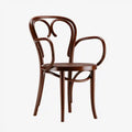Sedia marrone con braccioli curvi e schienale decorativo aperto